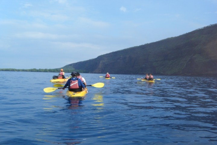 a group of people in a small boat in a body of water